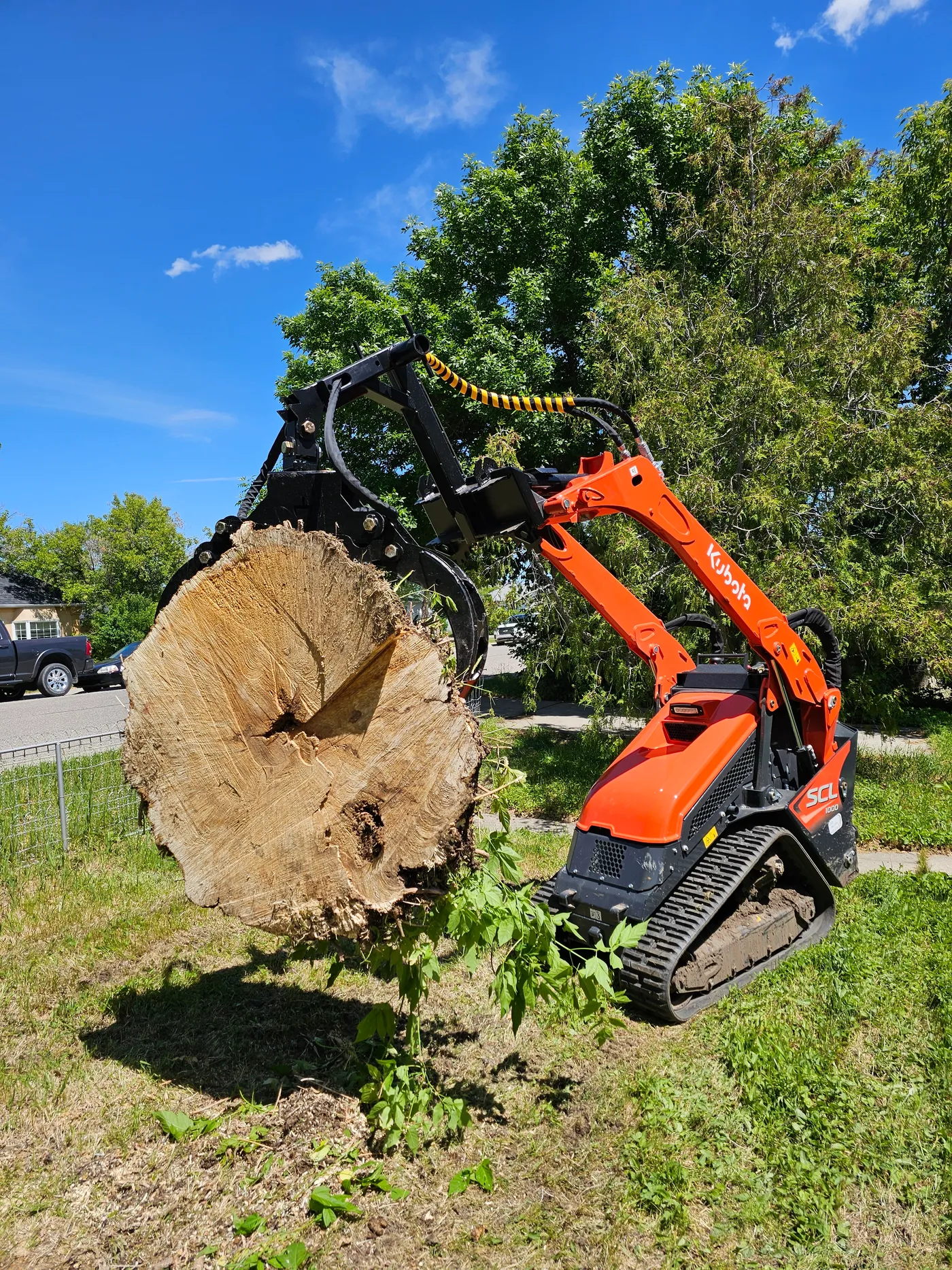 Compact loader carrying a large cut log section